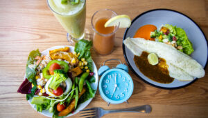 Photo of a selection of meals and a clock signifying intermittent fasting