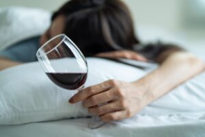 Photo of woman sleeping with a glass of wine in her hand
