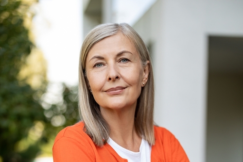 Calm, composed woman in her fifties looking directly at camera, representing clarity around midlife symptoms often mistaken for menopause or thyroid issues